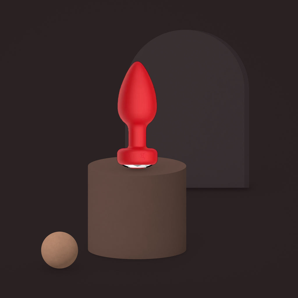 Magpie, app-controlled vibrating jewel plug, on a ceramic plinth (Red)